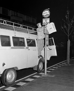 855102 Afbeelding van het verwisselen van een bord op een bushalte voor stadsbussen in de wijk Overvecht te Utrecht. ...